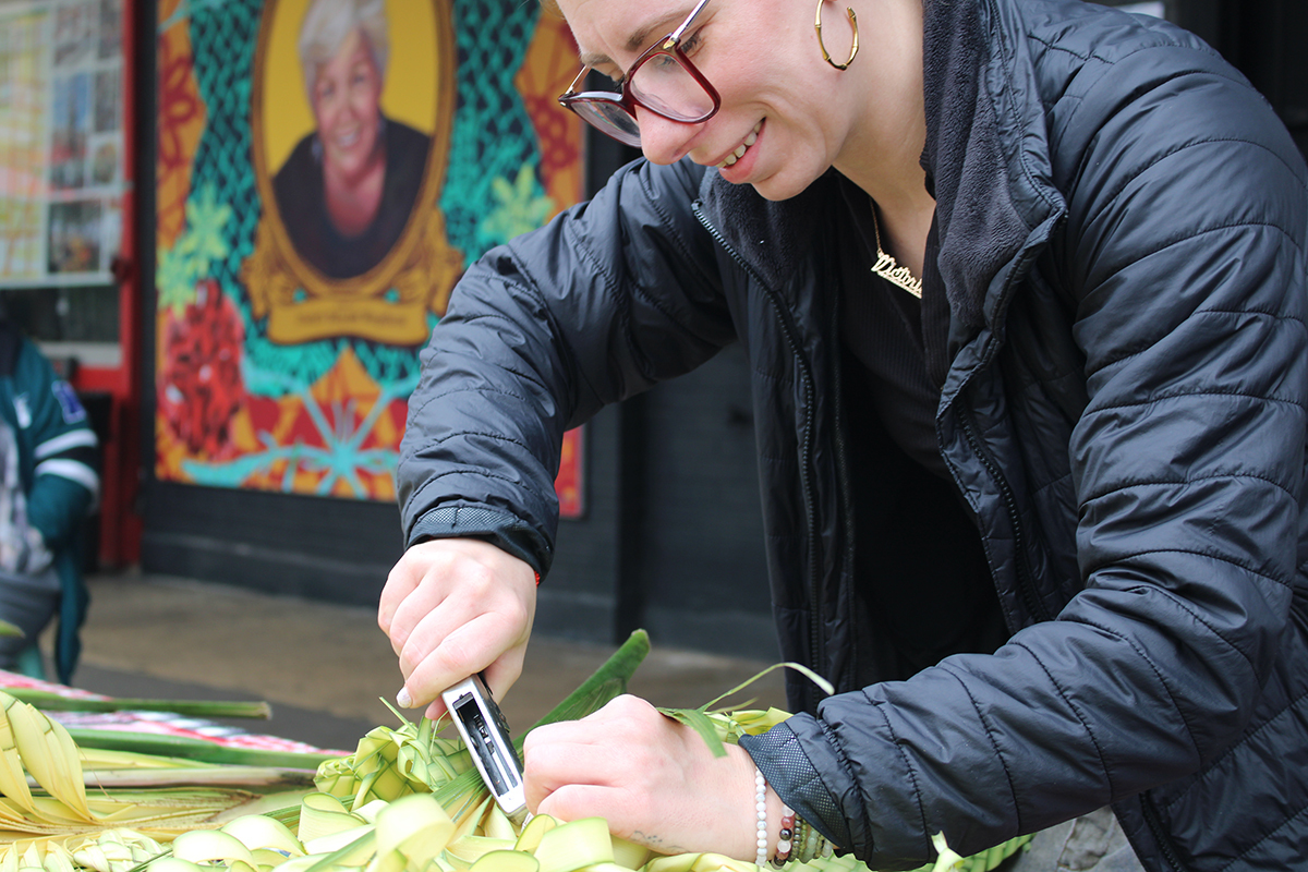 A woman weaves designs with palm fronds in Philadelphia's Italian market.