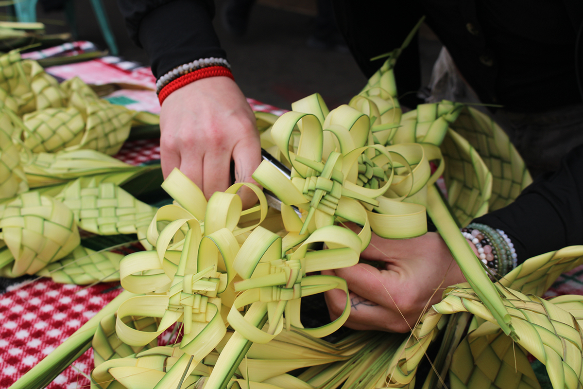A woman weaves designs with palm fronds in Philadelphia's Italian market.
