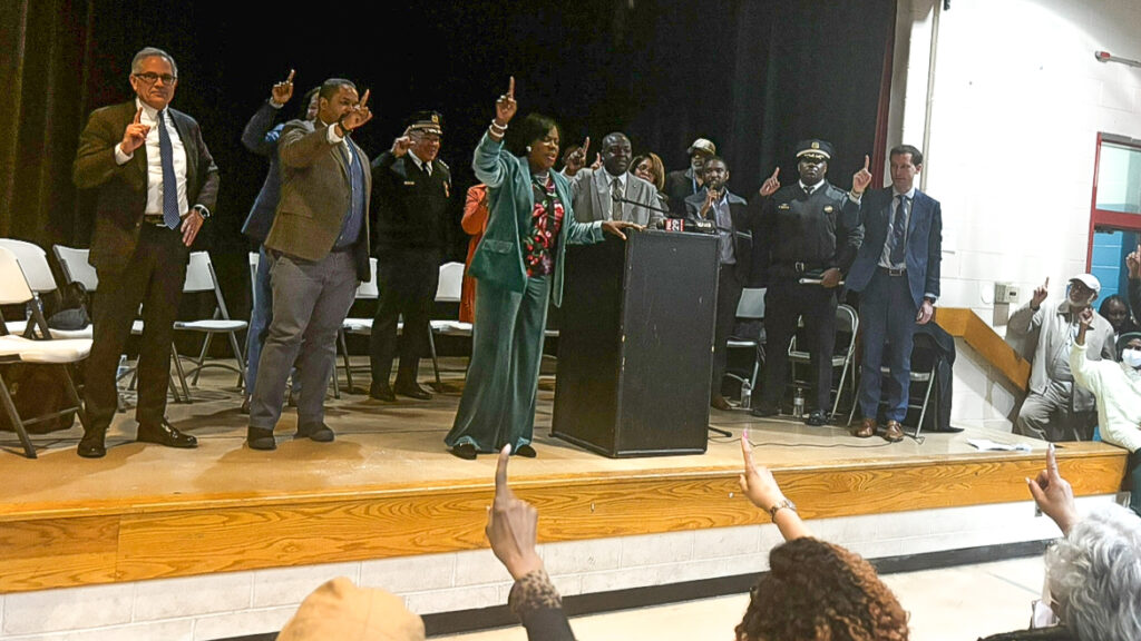 Mayor Parker and other officials on the stage, all holding up one finger