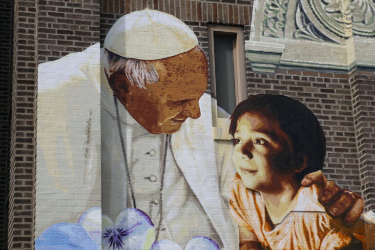 Mural of Pope Francis and child on the facade of Saint Malachy School