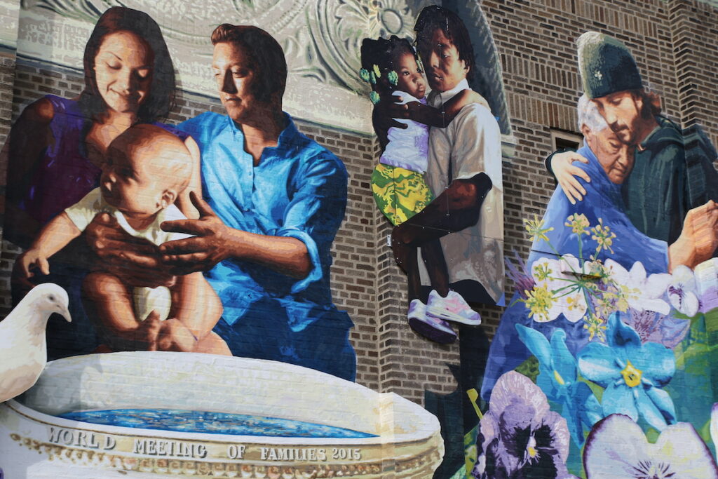Mural of several people on the facade of Saint Malachy School