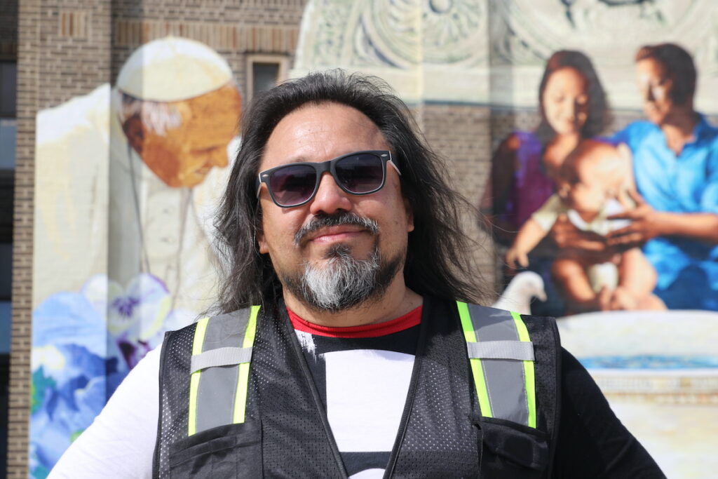Mural designer Cesar Viveros in front of mural