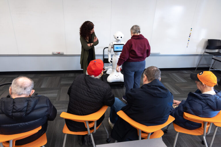 Adult residents at Bancroft's Flicker program interacting with robot