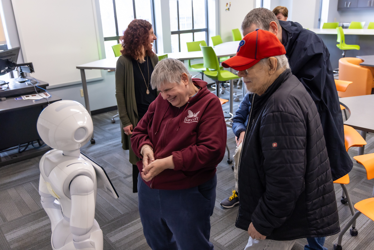 Adult residents at Bancroft's Flicker program interacting with robot