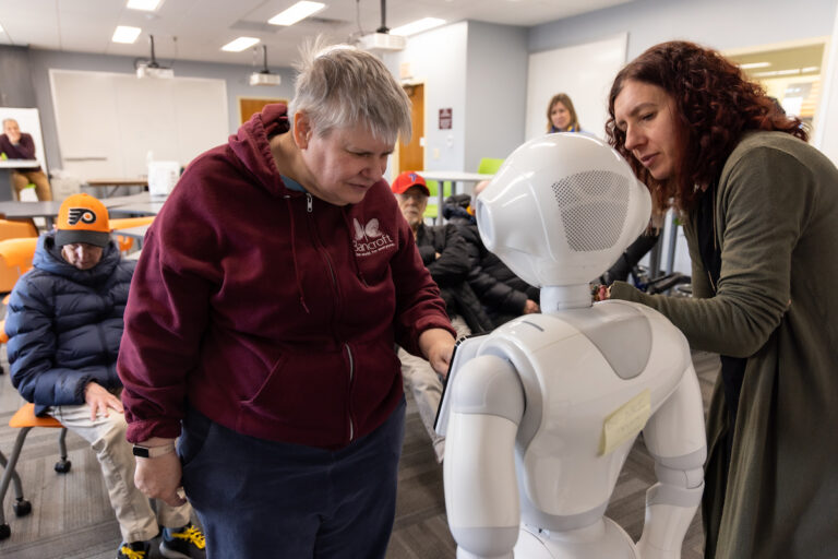 Saint Joseph’s University researcher Sara Girotto works with Bancroft resident to answer trivia questions on robot