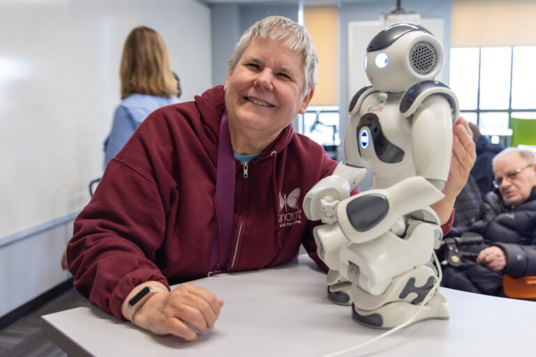 Resident from Bancroft’s Flicker program lovingly poses with robot