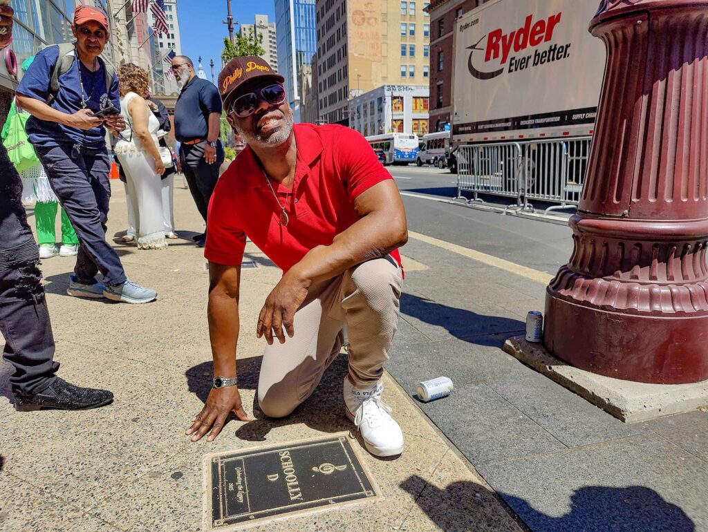walk-of-fame-p-crimmins-2025-04-30-1 Schoolly D posing for a photo with his plaque on the walk of fame