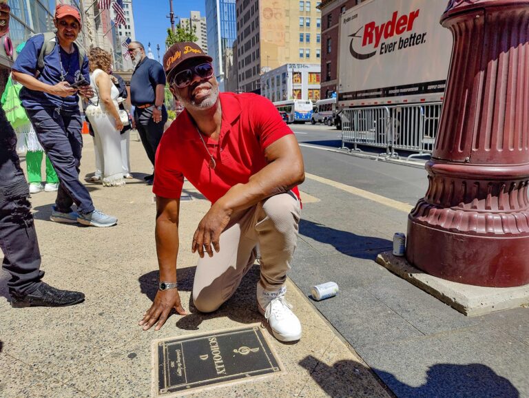 Schoolly D posing for a photo with his plaque on the walk of fame