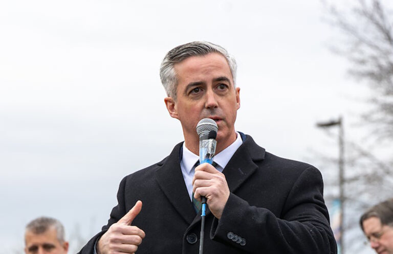 Bob Harvie speaking into a microphone at a press conference