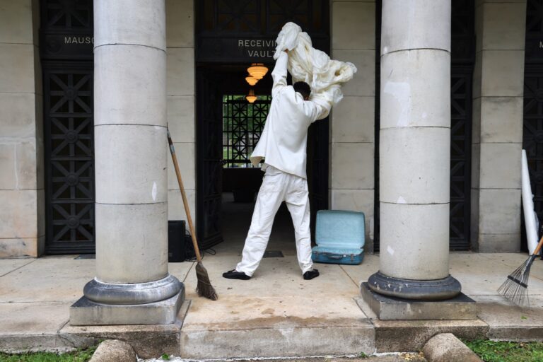 DonChristian Jones sweeps the entrance to Laurel Hill Cemetery's Receiving Vault for the Death and Arts Festival