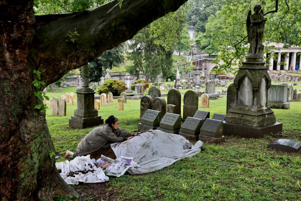 2025 05 28-e lee-eiko atake-philadelphia laurel hill cemetery-a body in places site Eiko Otake scatters dirt over an image of her mother at Laurel Hill Cemetery for the Death and Arts Festival