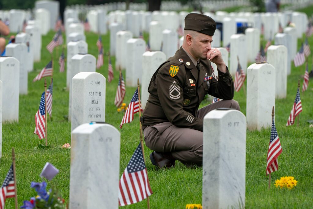Army-member-Arlington-National-Cemetery A member of the Army keels by a tombstone in Section 60 of Arlington National Cemetery