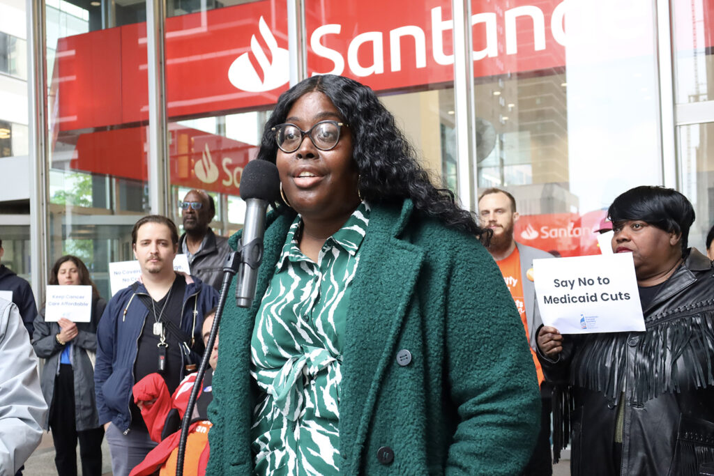 A woman speaks into a microphone at a rally against Medicaid cuts in Philadelphia