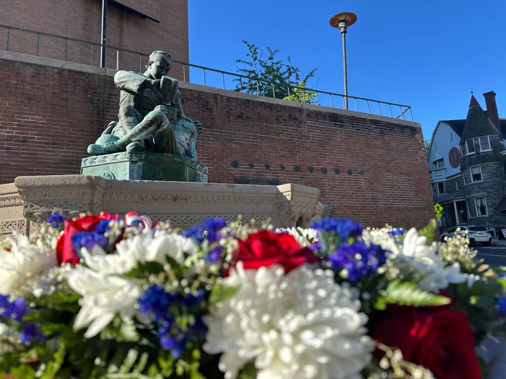 A wreath is laid before a war memorial statue