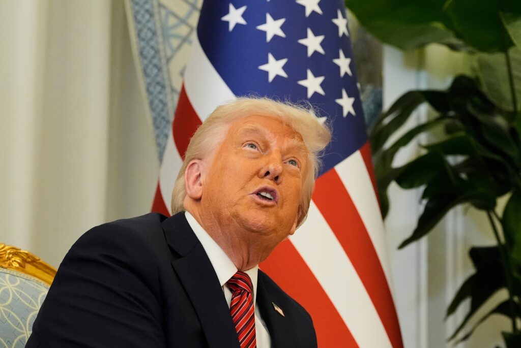 President-Donald-Trump-2025-05-14 Donald Trump sits in front of an American flag