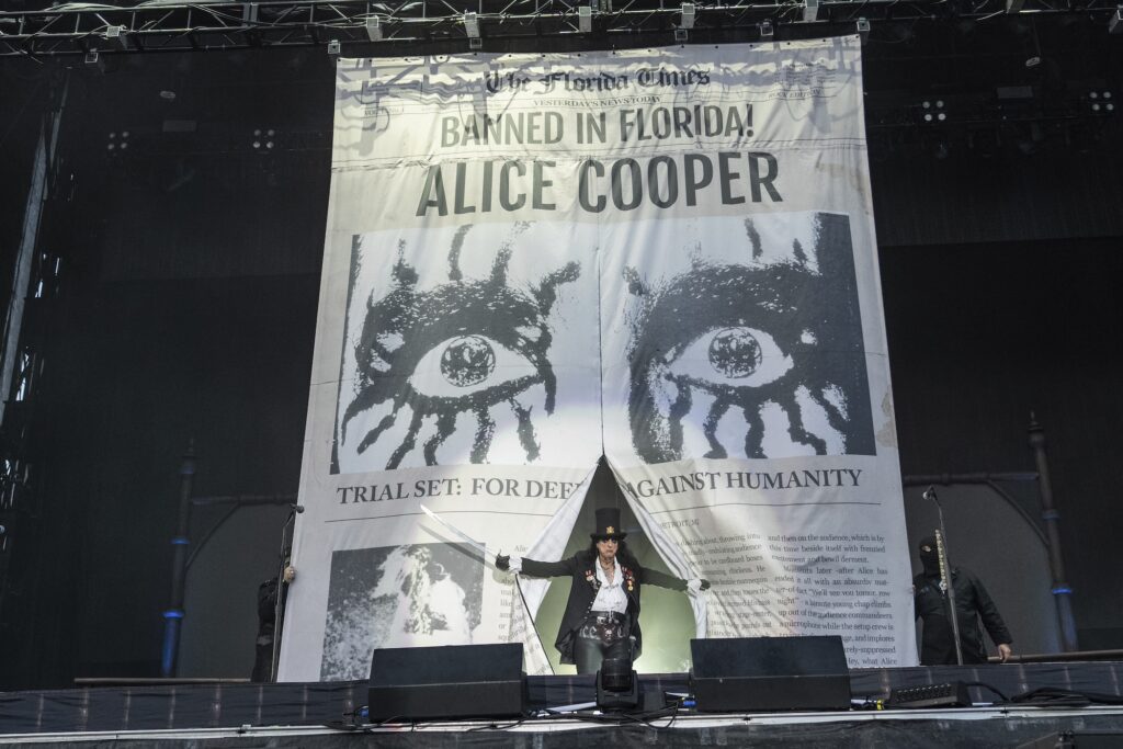 Alice Cooper entering the stage from behind a large backdrop