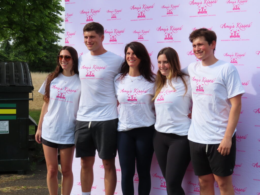 A group of people wearing 'Amy's Kisses' shirts