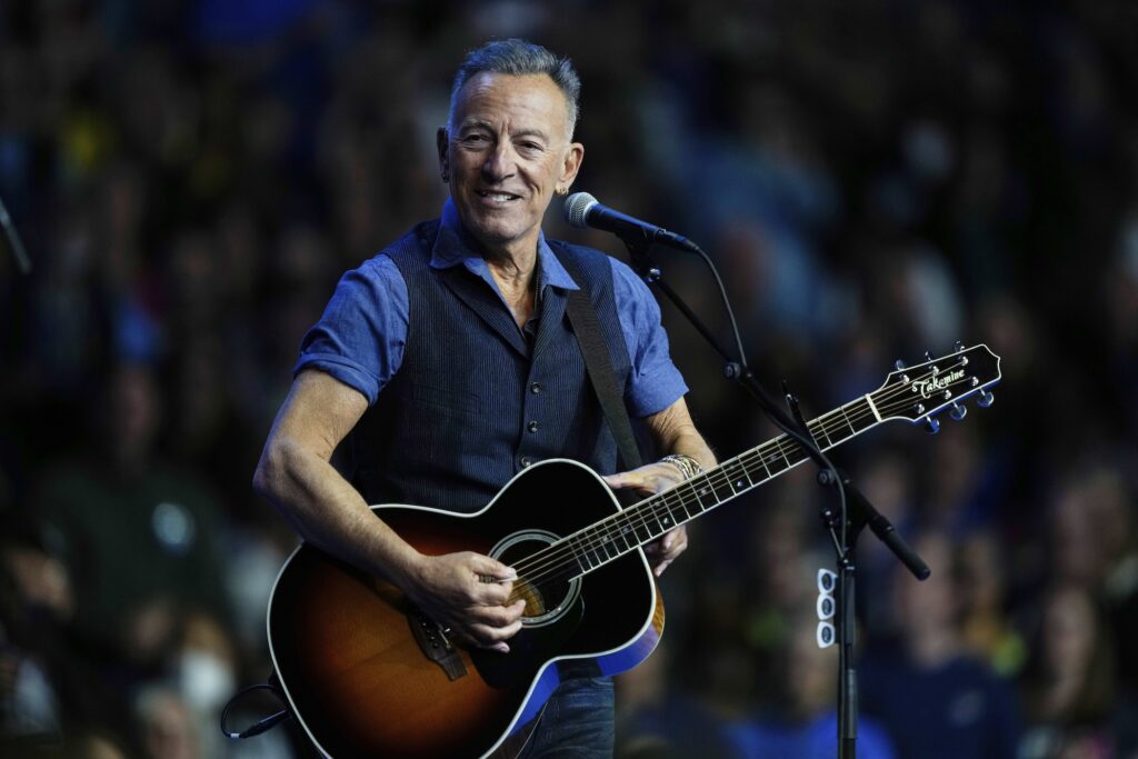 Springsteen And Trump Bruce Springsteen performing on stage with a guitar
