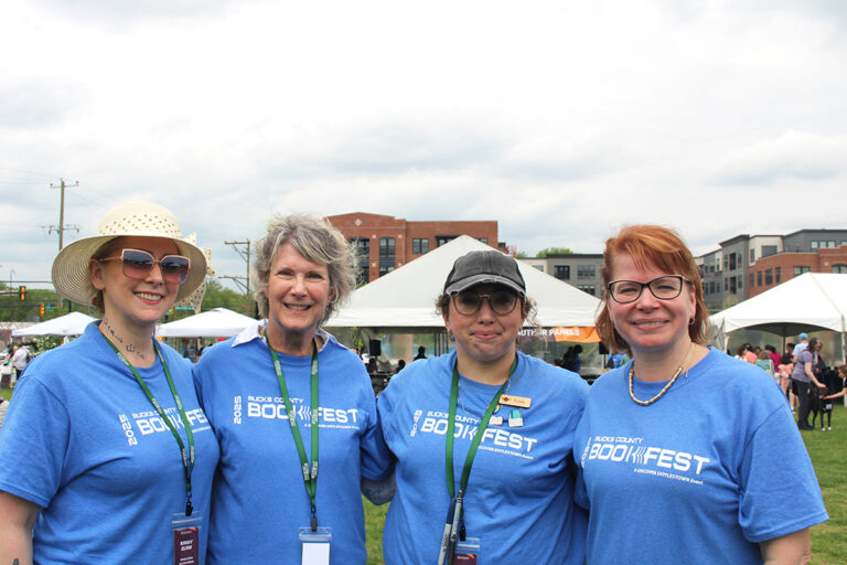 From left, Krisy Elisii, Glenda Childs, Kate Steck and Lauren Ford, organizers of the seventh annual Bucks County Book Festival, pose for a photo on Saturday, May 3, 2025, at Broad Commons Park in Doylestown. (Emily Neil/WHYY)