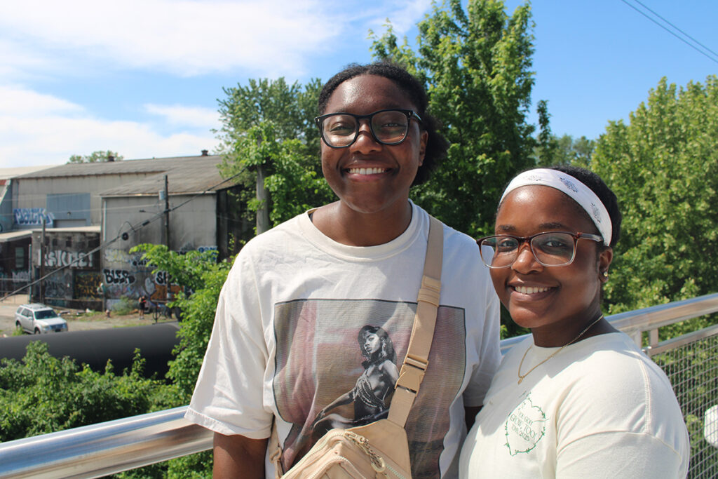 Two women smile at the camera as they enjoy the newest section of the Schuylkill River Trail in Philadelphia