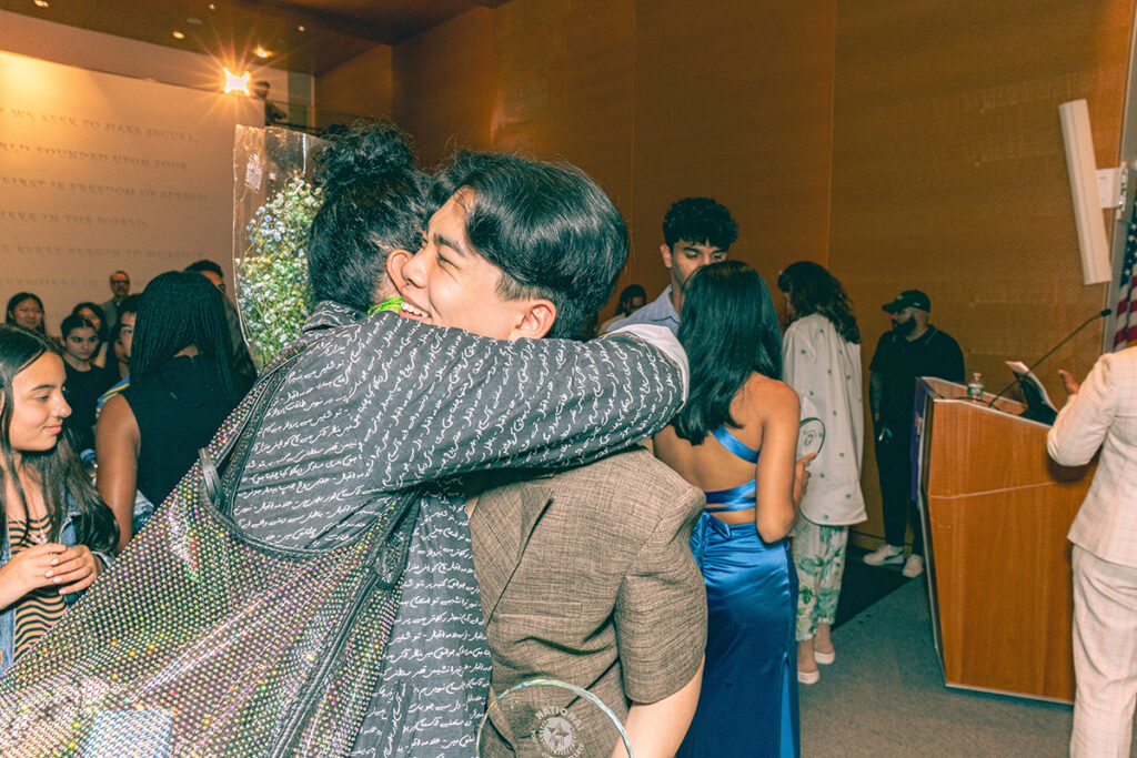 Evan Wang hugs a woman while celebrating at the National Youth Poet Laureate Commencement