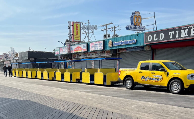 A hybrid Ford Maverick truck towing the tram car on the Wildwood Boardwalk