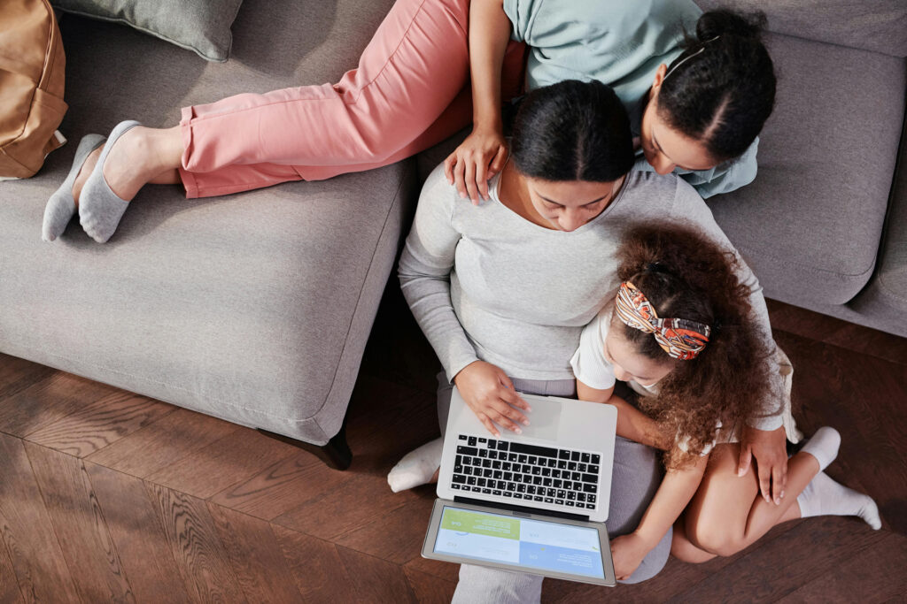 Mother and Daughters Sitting with Laptop