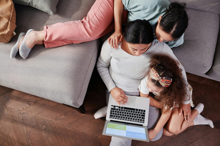 Mother and Daughters Sitting with Laptop