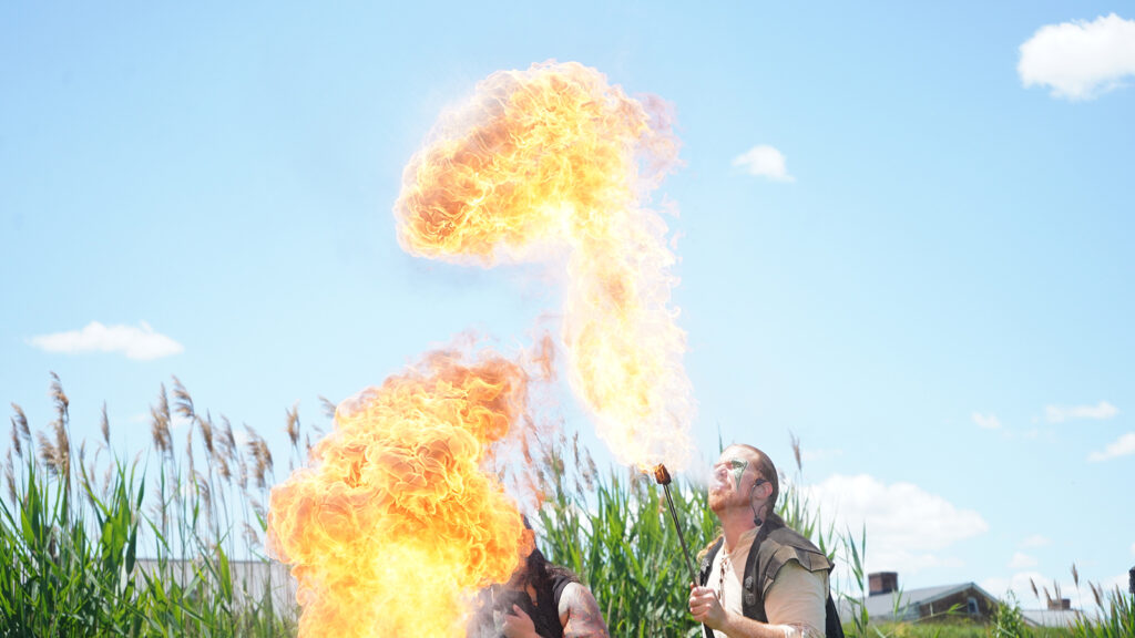 Bella GreenWolf and Daniel GreenWolf breathe fire to cap off their performance. (Kenny Cooper/WHYY)