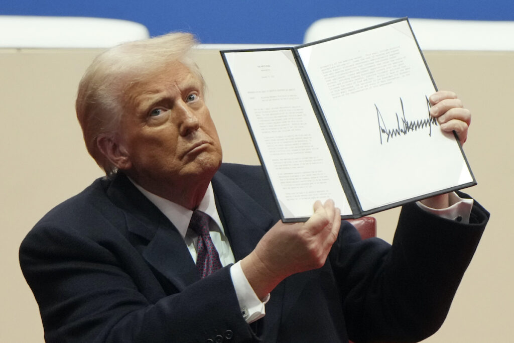 Trump Transgender Health Policy President Donald Trump holding up executive order
