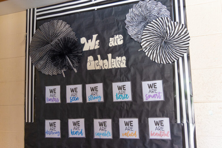 a wall piece reads We are Scholars and other motivational phrases