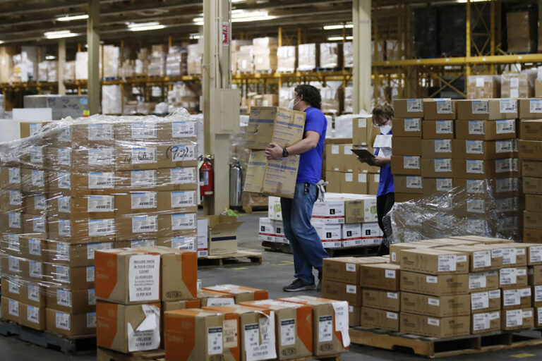 Workers carry boxes in a warehouse