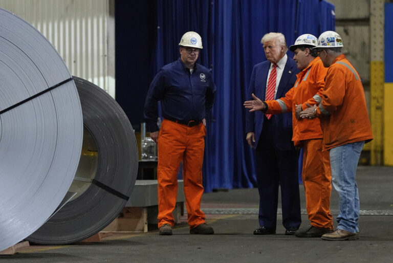 President Donald Trump talks to steel workers