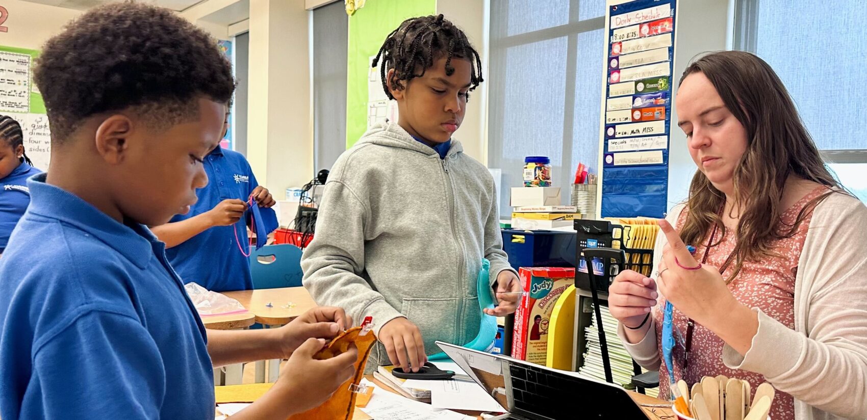 Emma Salisbury helps two students with a puppet