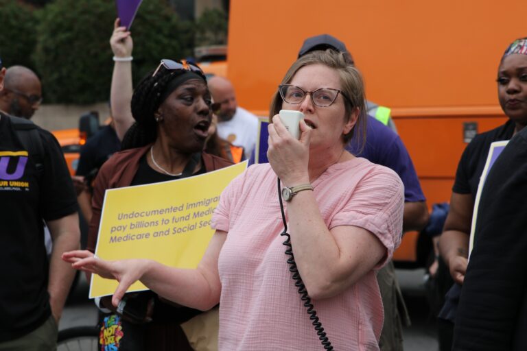 A woman speaking into a megaphone at the protest