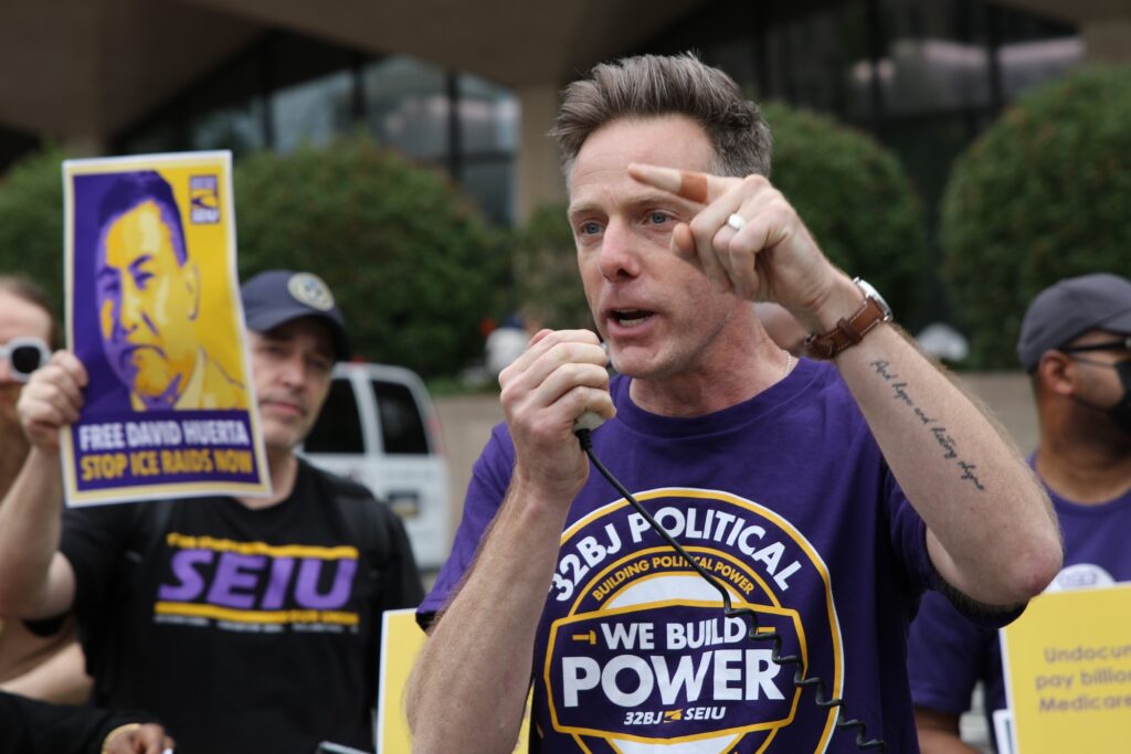 A man speaking into a megaphone at the protest