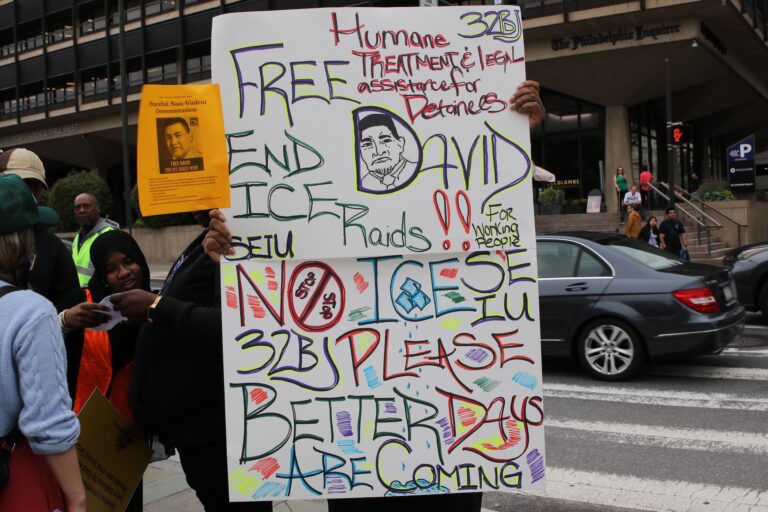 People holding up signs as they gather at the protest
