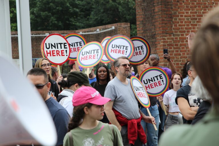 People holding up signs as they gather at the protest
