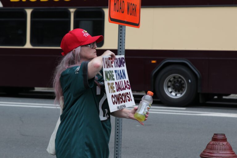 People holding up signs as they gather at the protest