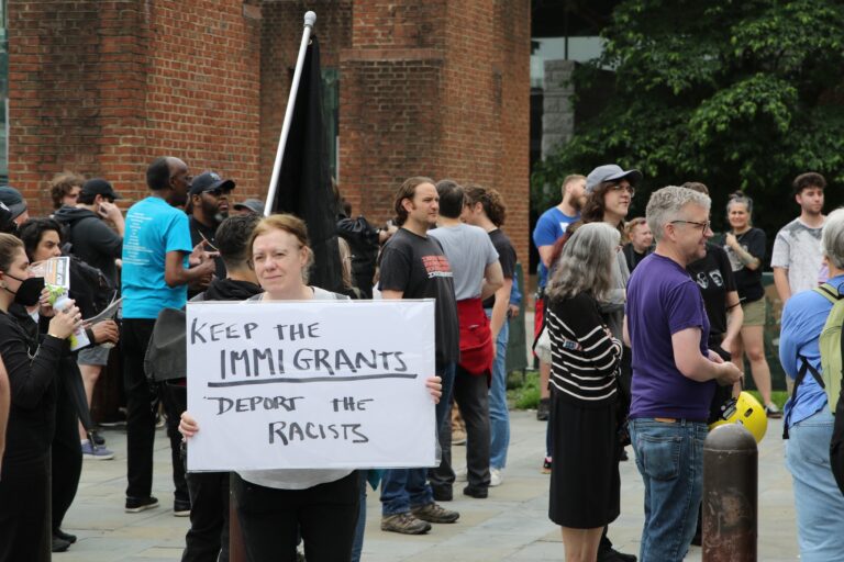 People holding up signs as they gather at the protest