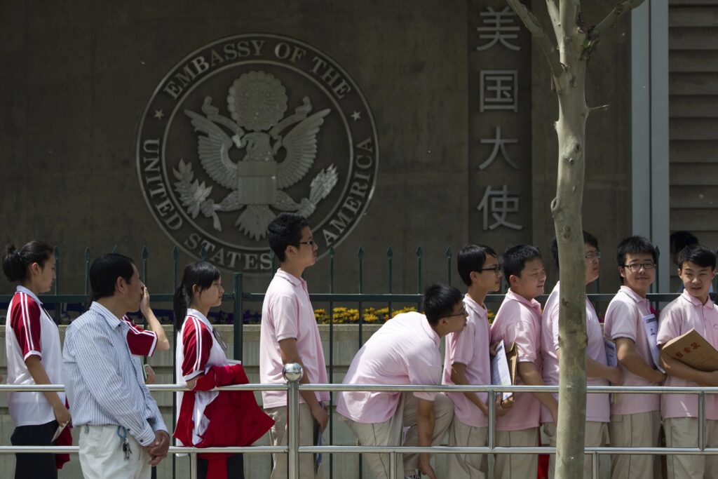 China US Explainer Students waiting in line in front of the Embassy