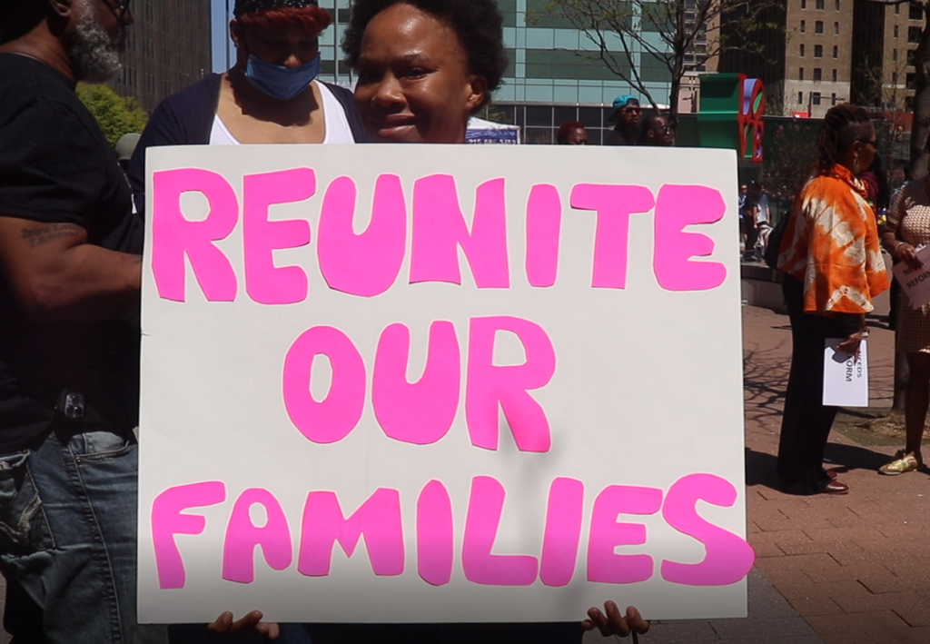 families-protest-2025-06-05 A woman holding up a sign that says 'Reunite our Families'