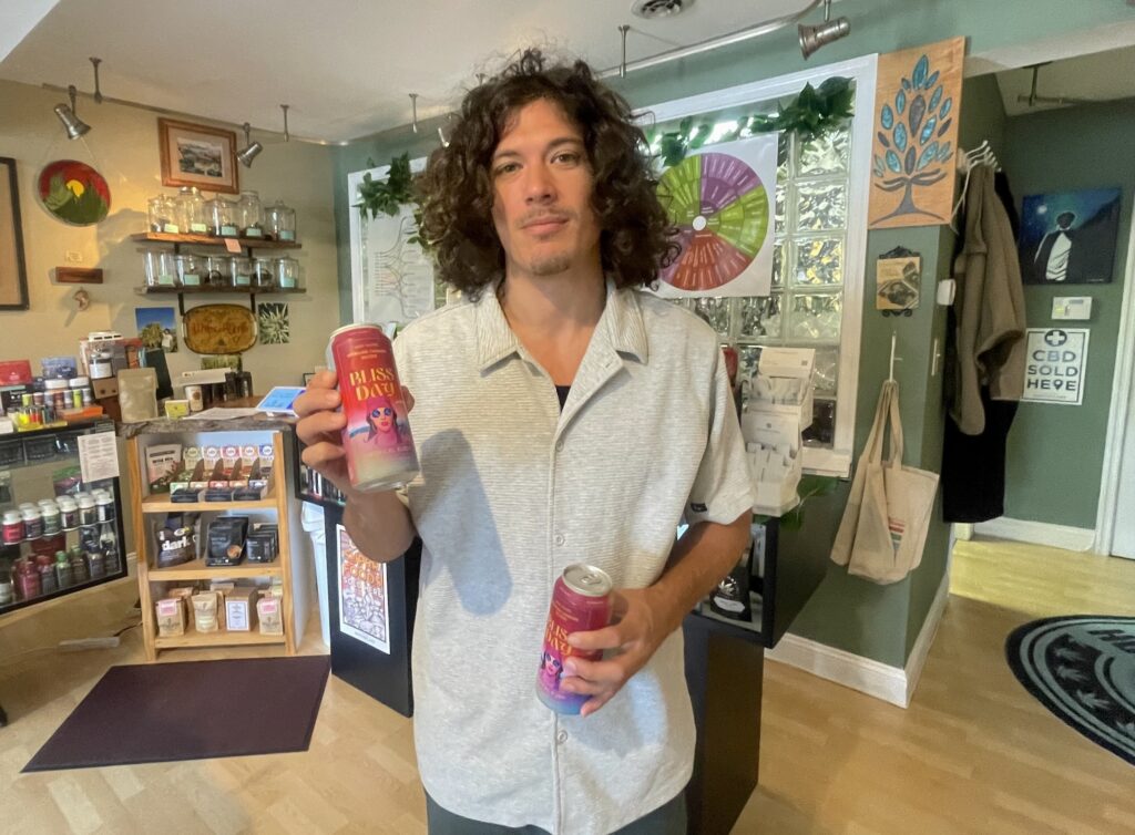 Jesse Ginefra with cans of the drink in his store