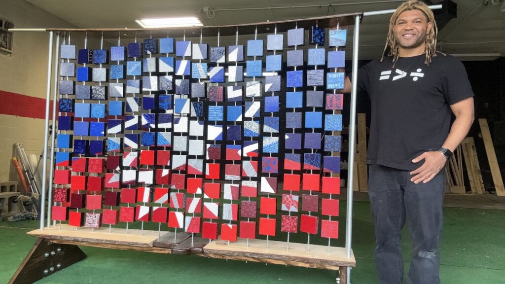 juneteenth-flag-artist-EN-061325-02 Kevin Aster Young posing with artwork
