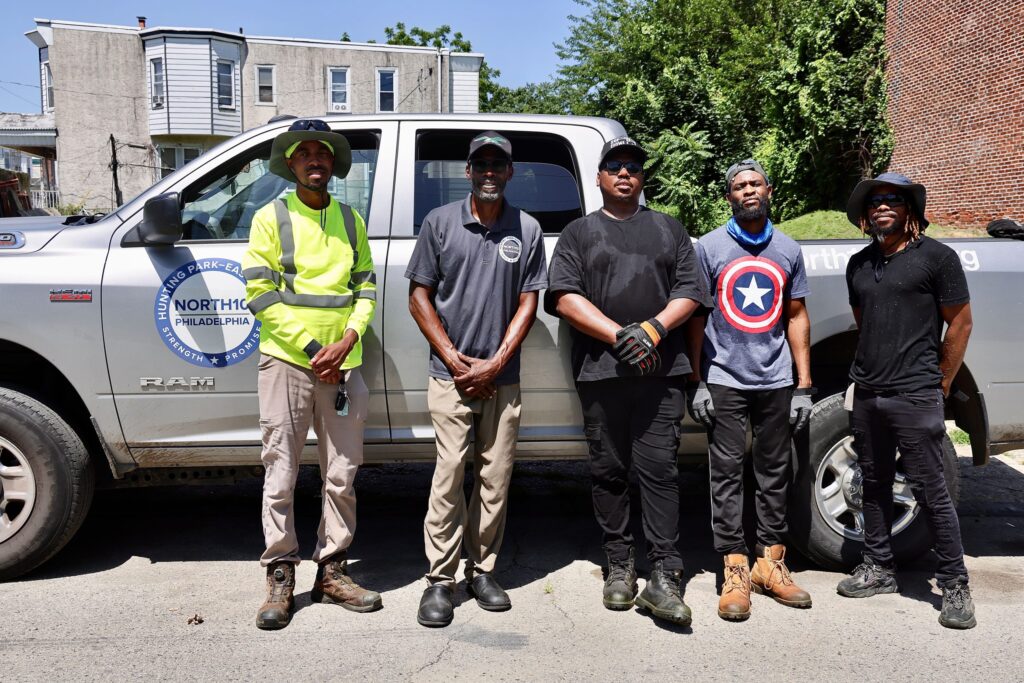 north-10-philadelphia-e-lee-2025-06-30 A group of men in work clothes posing for a photo standing in front of a pickup truck