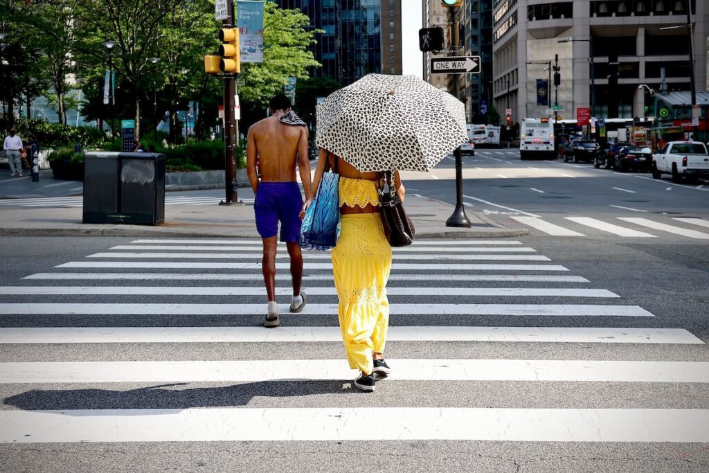 philadelphia-centercity-heatwave-EL-062325-02 A woman uses an umbrella for shade in Philadelphia