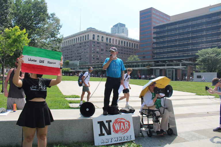 A woman holds a Palestinian flag with words on it that read 