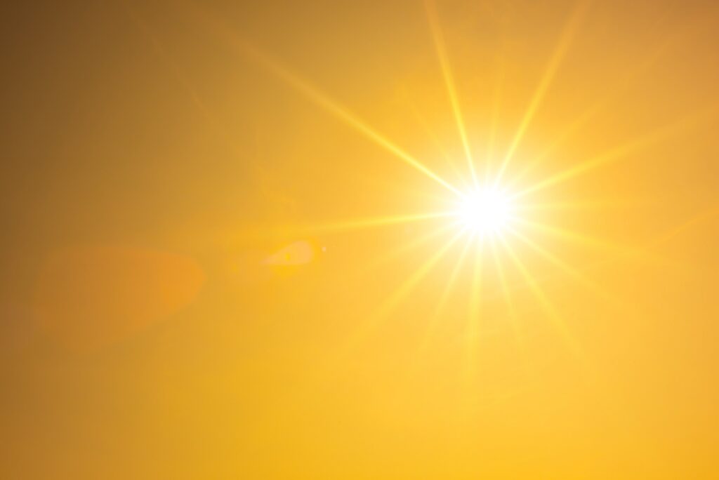 Summer background, orange sky with glowing sun