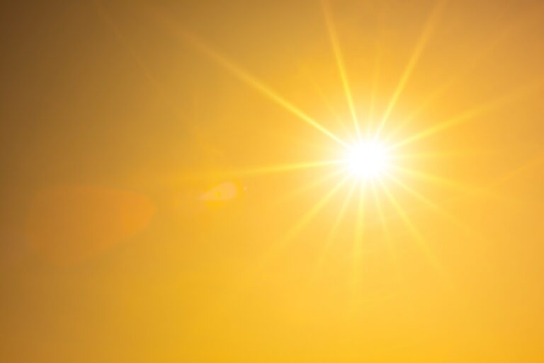 Summer background, orange sky with glowing sun