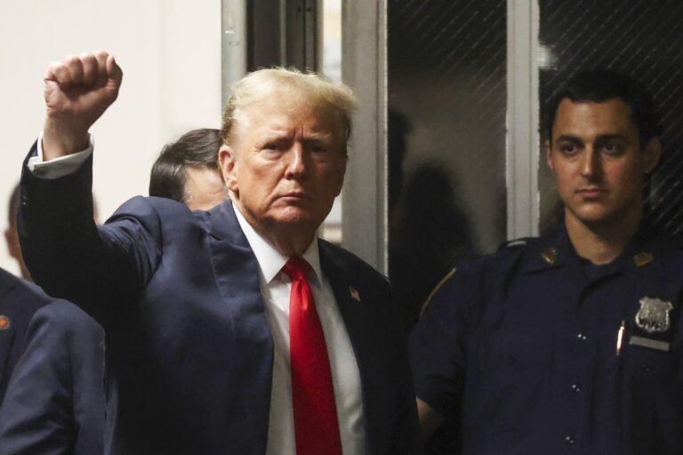 Donald Trump raising a fist to supporters.